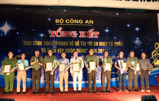 Đồng chí Thượng tá Nguyễn Thanh Liêm - Phó giám đốc Công an tỉnh Hà Tĩnh; PGS - TS, nhạc sĩ Thế Bảo trao giấy chứng nhận cho các nhạc sĩ tham gia trại sáng tác âm nhạc.