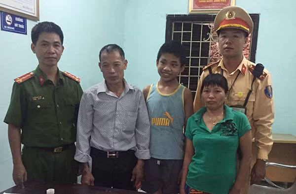 Cán bộ Đội CSGT số 14 Phòng CSGT Công an TP Hà Nội trao trả em bé bị lạc về với gia đình.