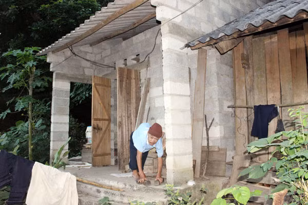 Ông Lâm Văn Sạch trước ngôi nhà của mình.