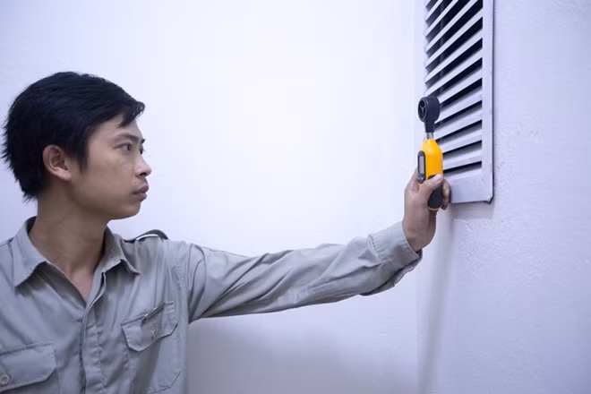 Kỹ thuật viên đang sử dụng thiết bị chuyên dụng để kiểm tra gió trong buồng thang khi hệ thống điều áp được tự động kích hoạt.
