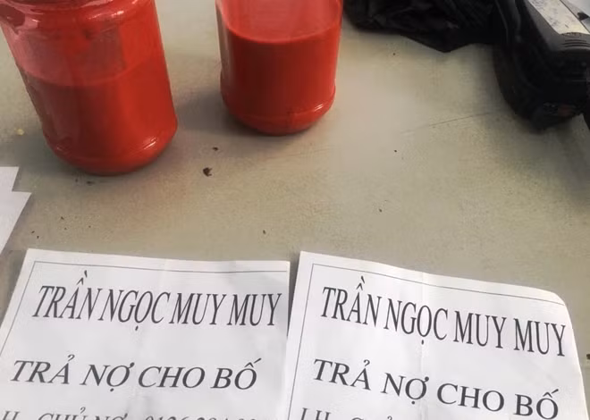 Hai bình sơn đỏ và tờ giấy đòi nợ các đối tượng dự định mang đến nhà ông Trần Ngọc M.M.