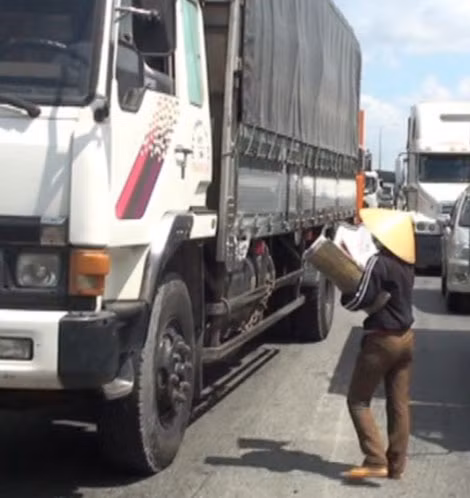 Chị Thủy xông ra đứng giữa vạch sơn mong manh ngăn cách hai chiếc xe tải đang cuồn cuộn lăn bánh.