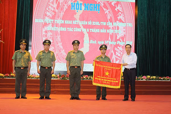 Thừa ủy quyền của Chủ tịch nước, đồng chí Nguyễn Văn Quang, , Chủ tịch UBND tỉnh Hoà Bình trao cờ thi đua cho đơn vị Phòng An ninh điều tra.