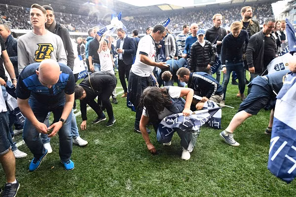 Các CĐV Tottenham xuống sân sau khi trận đấu kết thúc và lấy cỏ mang về. Ảnh: Reuters.