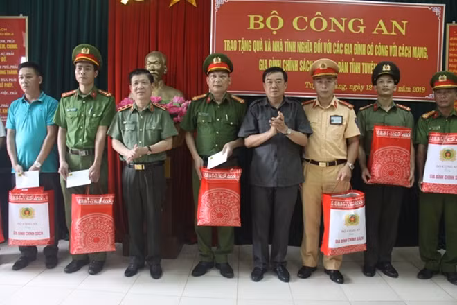Thứ trưởng Nguyễn Văn Sơn và đồng chí Nguyễn Hồng Thắng trao phần quà cho các gia đình .