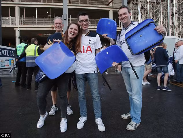 Các cổ động viên Tottenham "khoe" những ghế lấy từ khán đài. Ảnh: PA