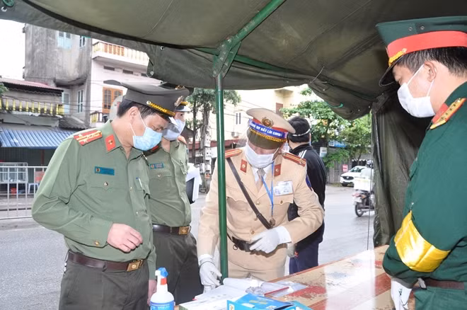 Đại tá Lê Ngọc Châu kiểm tra việc ghi chép thông tin tại chốt kiểm soát trên địa bàn huyện Kim Thành.
