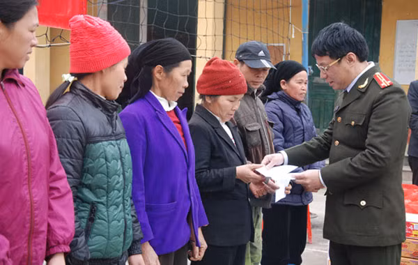 Thượng tá Phạm Quang Khải, Phó Tổng biên tập Báo CAND cùng đại diện Công an tỉnh Cao Bằng trao quà Tết tới đồng bào nghèo xã Thụy Hùng (Cao Bằng).