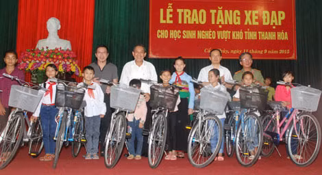 Đồng chí Trương Hòa Bình cùng lãnh đạo tỉnh Thanh Hóa, lãnh đạo Báo CAND và ông Lâm Tấn Lợi trao tặng xe đạp cho các cháu học sinh nghèo hiếu học ở huyện Cẩm Thủy.