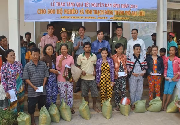 Đại diện Báo CAND, Công ty TNHH TM-XD-DL Công Lý, Công an tỉnh Bạc Liêu, cấp ủy, chính quyền xã Vĩnh Trạch Đông tặng quà cho hộ dân nghèo của xã.