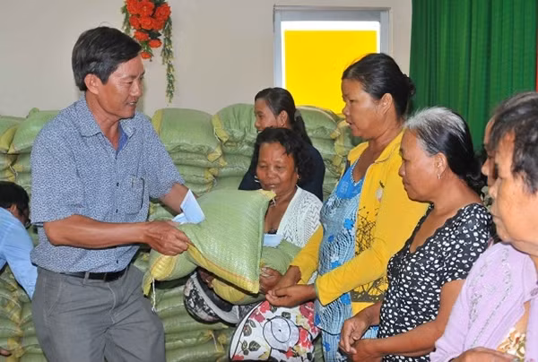 Đại diện Công ty TNHH TM-XD-DL Công Lý tặng quà cho hộ dân nghèo của xã Vĩnh Trạch Đông.