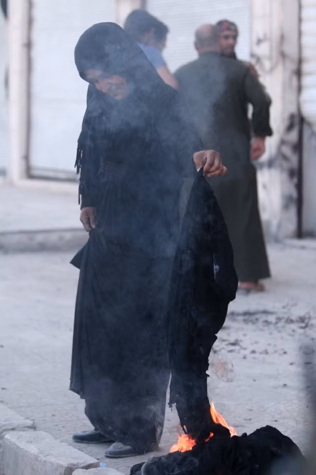 Một phụ nữ Syria đốt khăn choàng niqab sau khi được giải phóng khỏi IS