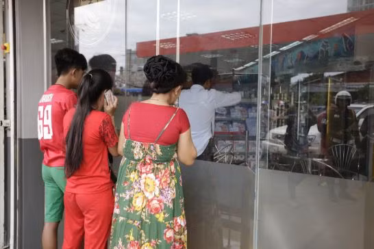 Vợ (mặc váy hoa, phải) và con gái (quần áo đỏ, giữa) của ông Kemley tại hiện trường vụ án, họ rất đau lòng