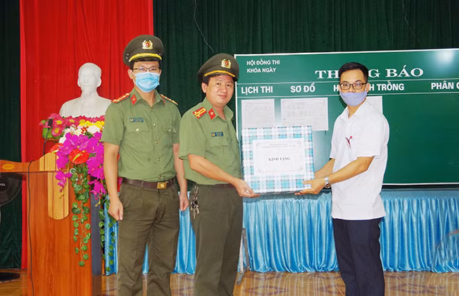 Đại diện lãnh đạo phòng Công tác đảng và công tác chính trị; Đoàn thanh niên Công an tỉnh Hà Nam tặng khẩu trang phòng, chống dịch COVID-19 cho Hội đồng thi trường THPT A Phủ Lý