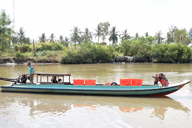 Những bồn chứa nước ngọt lên ghe xuồng về với các hộ dân nghèo giúp đẩy lùi cơn hạn mặn