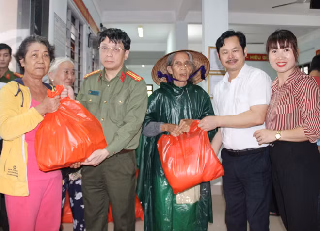 Đại tá Phạm Khải, Tổng Biên tập Báo CAND cùng ông Nguyễn Huy Hoàng, Chủ tịch Công đoàn Công ty CP Đầu tư Văn Phú - Invest trao quà cho người dân xã Vinh Hiền, huyện Phú Lộc (tỉnh Thừa Thiên-Huế).