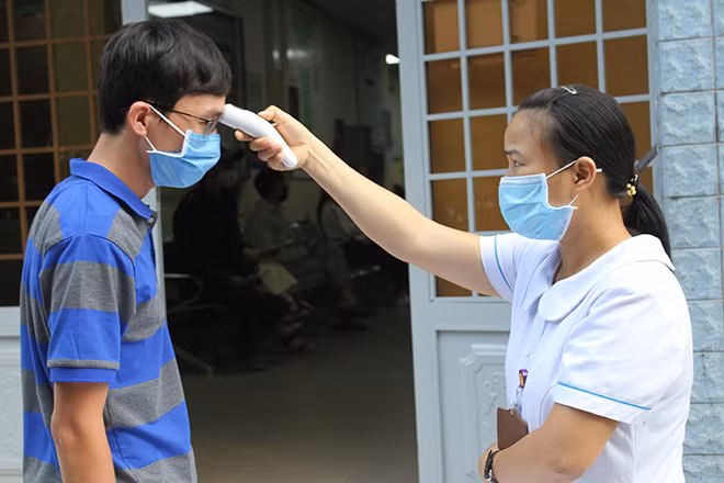 Người đến khám bệnh đều được đo nhiệt độ.