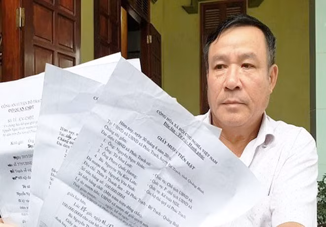 Một người dân cầm giấy mượn tiền của UBND xã Phúc Trạch phản ánh sự việc với phóng viên.