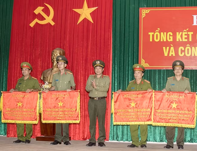 Đại tá Nguyễn Văn Hiểu, Giám đốc Công an tỉnh Vĩnh Long, thừa ủy quyền của Bộ trưởng Bộ Công an trao cờ thi đua xuất sắc của Bộ Công an cho 4 đơn vị dẫn đầu.