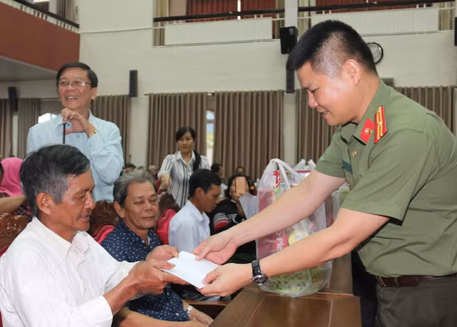 Thiếu tá Nguyễn Văn Bình, đại diện Báo CAND tặng quà cho gia đình chính sách.