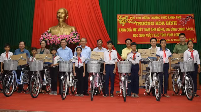 Phó Thủ tướng Trương Hoà Bình cùng lãnh đạo Tỉnh uỷ, UBND tỉnh Vĩnh Long và các đại biểu trao, tặng xe đạp cho học sinh vượt khó.