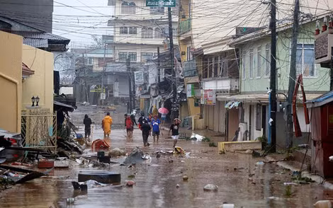 Người dân Philippines lội qua đoạn đường ngập ở thành phố Borongan, tỉnh Samar. Ảnh: EPA.