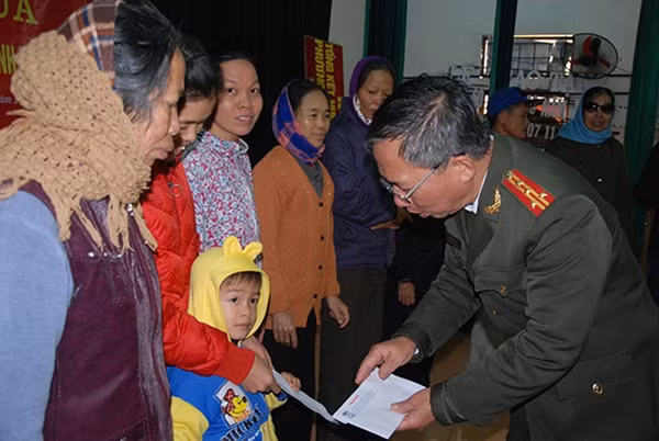 Đại tá Đăng Văn Lân trao quà cho các hộ gia đình có hoàn cảnh khó khăn tại xã Xuân Châu, huyện Xuân Trường.