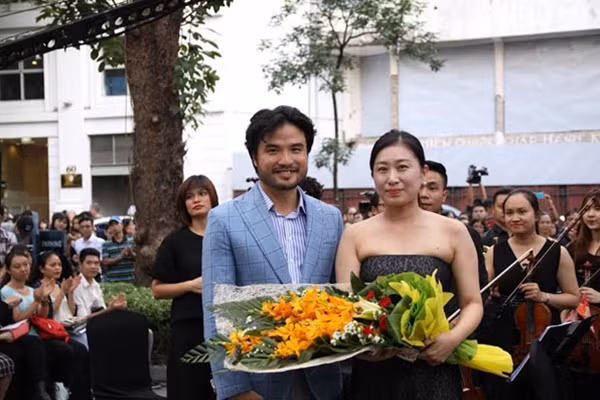 Ông Đỗ Ngọc Minh lên trao hoa cho nghệ sĩ piano Boomi Jang.