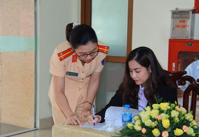 Cán bộ Cục CSGT hướng dẫn người dân trả lời câu hỏi, cung cấp thông tin theo mẫu điều tra xã hội học