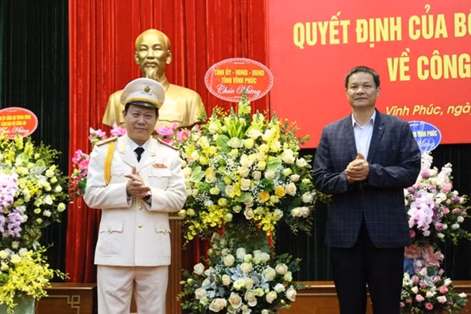Đồng chí Trần Văn Vĩnh tặng hoa chúc mừng Đại tá Đinh Ngọc Khoa