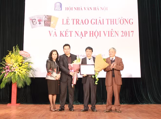 Lãnh đạo Hội Nhà văn Hà Nội cùng lãnh đạo NXB Văn học tặng hoa, trao Bằng Giải thưởng văn học 2017 cho nhà thơ, nhà phê bình Phạm Khải.