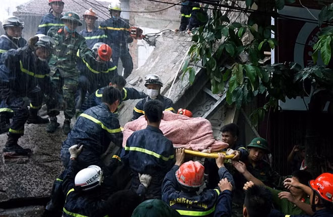 Đưa nạn nhân ra khỏi đống đổ nát trong cơn mưa tầm tã.