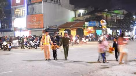 Các chiến sĩ Công an dắt một đứa trẻ bị lạc ba mẹ.