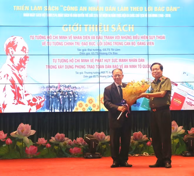 Thiếu tướng Đào Gia Bảo, Cục trưởng Cục Công tác Đảng và Công tác Chính trị tặng hoa GS.TS Hoàng Chí Bảo.