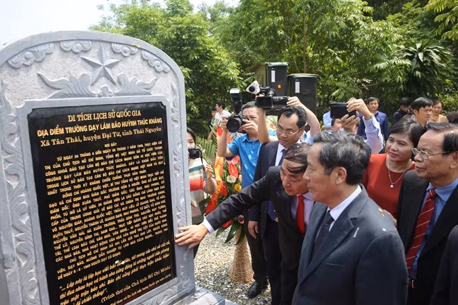 Các đại biểu tham quan Bia di tích lịch sử Quốc gia Trường Dạy làm báo Huỳnh Thúc Kháng.