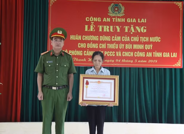 Thừa ủy quyền của Chủ tịch nước, Thượng tá Phạm Hữu Trường trao Huân chương Dũng cảm cho bà Trần Thị Chinh - mẹ Thiếu úy Bùi Minh Qúy