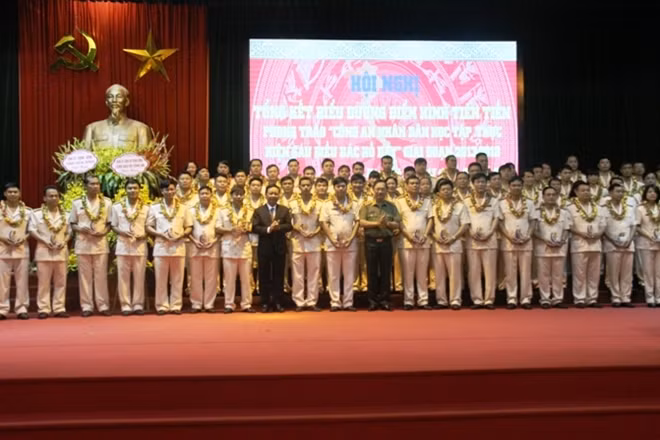 Thứ trưởng Nguyễn Văn Thành và đồng chí Bùi Văn Tỉnh trao biểu trưng Sáu điều Bác Hồ dạy cho các điển hình tiên tiến