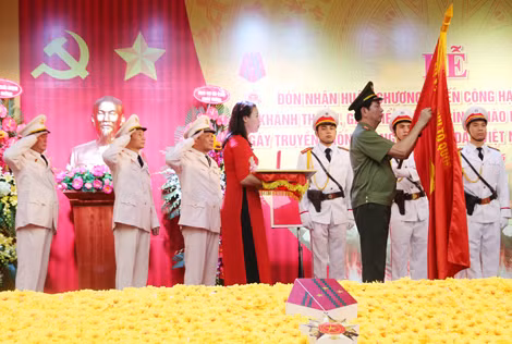 Bộ trưởng Trần Đại Quang gắn Huân chương chiến công hạng Nhất lên lá cờ truyền thống của Cảnh sát PC&CC TP Hà Nội.