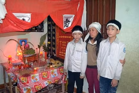 Vợ anh Trinh bên bàn thờ của nạn nhân xấu số.