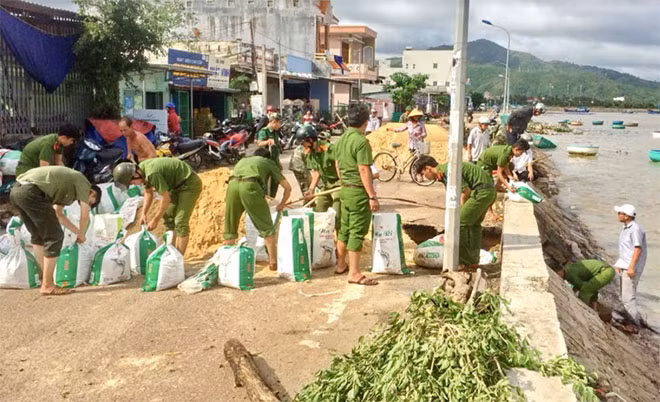 Công an thị xã Sông Cầu giúp dân gia cố bờ kè chắn sóng ở phường Xuân Thành.