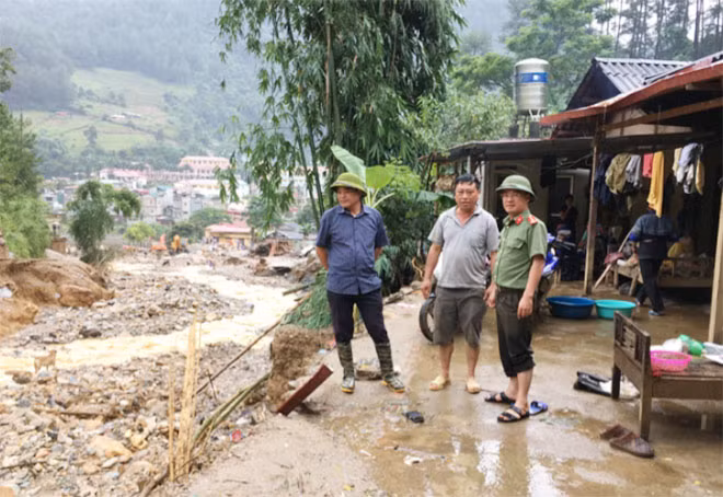 Đoàn công tác thăm hỏi gia đình trung tá Sùng A Của (đứng giữa), cán bộ Đội An ninh, Công an huyện Mù Cang Chải. Gia đình anh Của bị nước lũ bị trôi 1 phần tài sản.