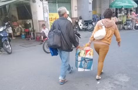 Vợ chồng bà Út cùng những gói tiếp phẩm cho con.