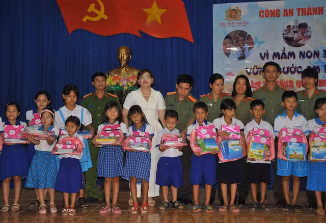 Thượng tá Nguyễn Phú Thương, Trưởng Công an quận Ô Môn trao quà cho các em học sinh.