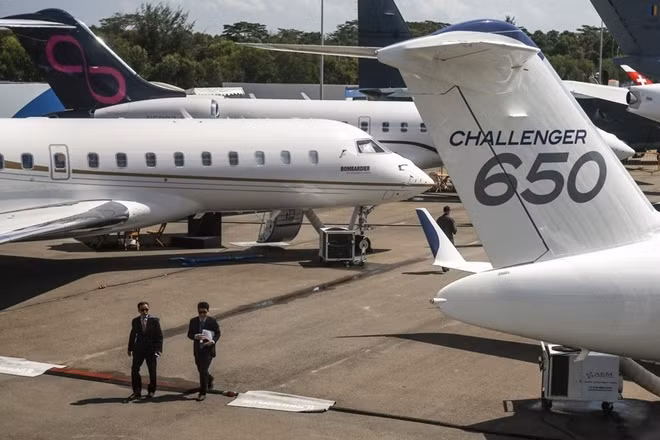 Khách tham quan đi qua những chiếc máy bay của hãng Bombardier (Canada) tại triễn lãm. Ảnh: EPA.