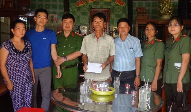 Đại tá Nguyễn Chí Công, Trưởng Công an thành phố trao tiền hỗ trợ cho gia đình Trung úy Nguyễn Văn Thiên Tường.