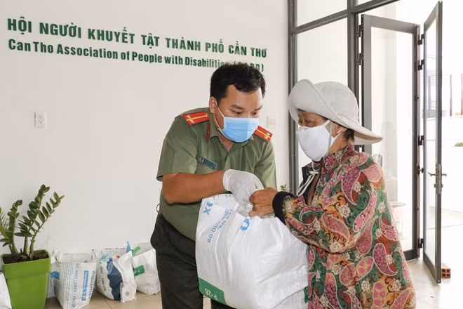 Trung úy Nguyễn Tứ Thiên, Bí Thư Đoàn Thanh niên Công an TP Cần Thơ tặng quà cho người khuyết tật.