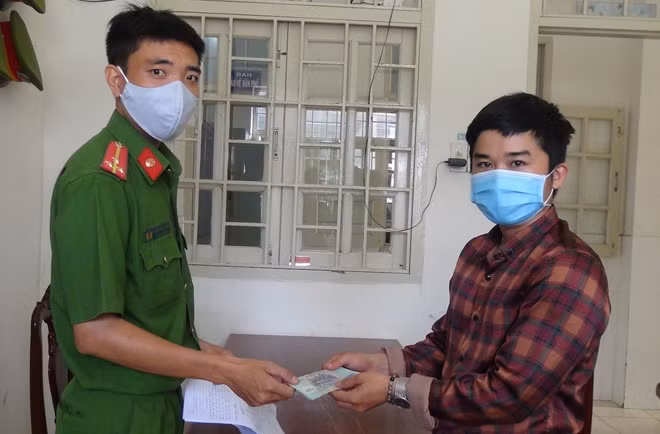 Cán bộ Công an phường 2 trao tiền lại cho anh Đức.