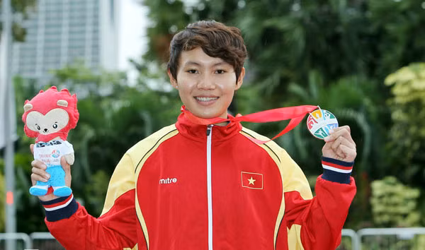 Nguyễn Thị Thật và chiếc huy chương vàng tại nội dung đua xe đạp đường trường của nữ. Ảnh: VNE.