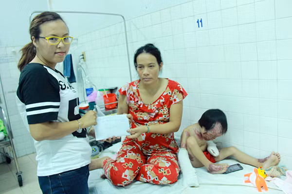 Chị Nguyễn Hoàng Nga đại diện cho Quỹ ủng hộ bé Ngô Công Tuấn Anh trao 17.450.000 đồng cho bé Tuấn Anh và gia đình.