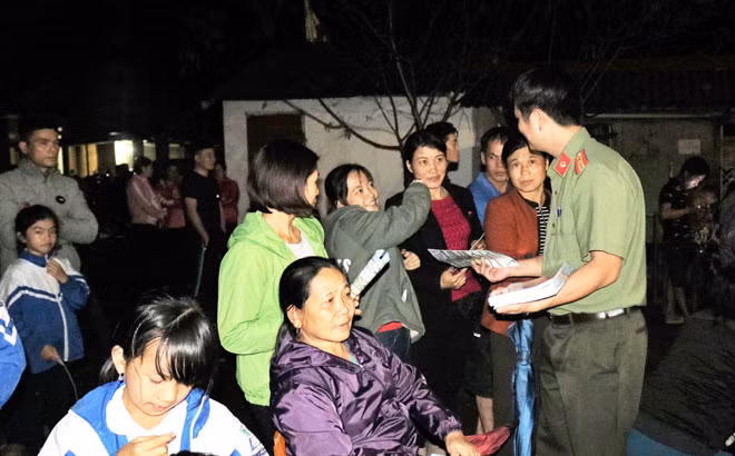Cán bộ Công an phát tờ rơi, tuyên truyền phổ biến pháp luật cho người dân tại xã Kim Hỷ, huyện Na Rì.